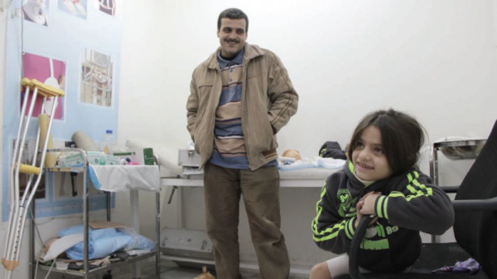 Safa, 7 ans avec son père. Photo Sarah Pierre Handicap International