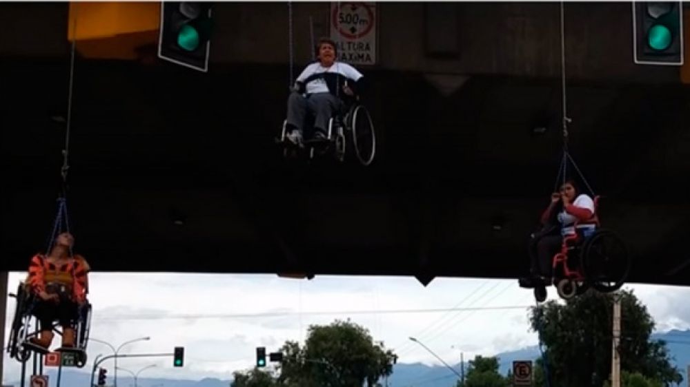 Des handicap&eacute;s Boliviens suspendus &agrave; un pont par leur fauteuil roulant 