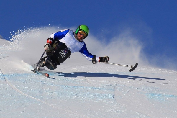 Skieur assis qui descend une piste