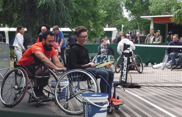 Michael Jérémiaz avec un jeune s'essayant au tennis fauteuil