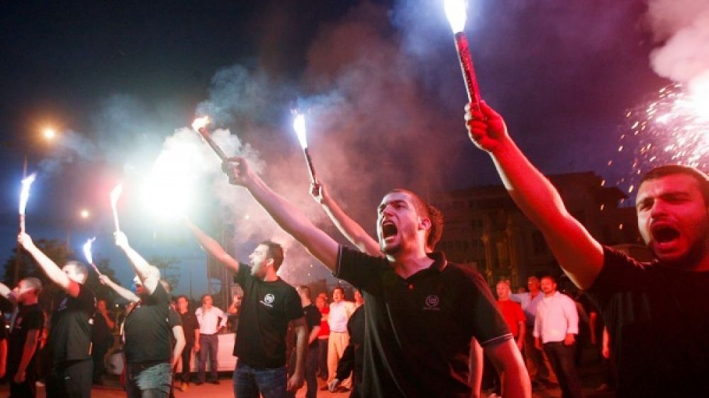 Les partisans d&#039;Aube Dor&eacute;e, le parti n&eacute;o-nazi grec, d&eacute;filent en faisant le salut nazi aid&eacute; de fus&eacute;es &eacute;clairantes