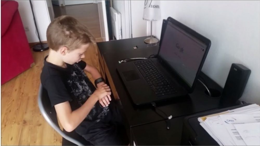 Le fils d'Estelle Ast en pleine utilisation d'une montre connectée.