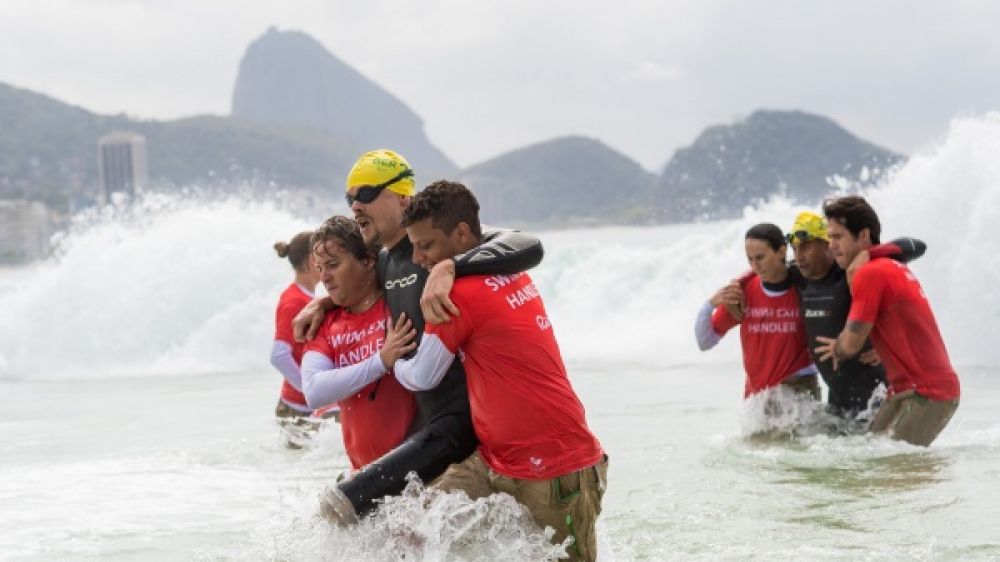 Sortie de l’eau d’un concurrent du triathlon fauteuil après ses 750m de nage en pleine mer.