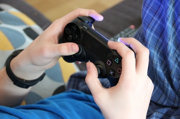 Les mains d'un enfant tenant une manette de jeu vidéo